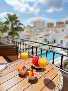 - une table en bois avec deux verres de jus et de fruits dans l'établissement Villa Barma Del Mar, à Torrevieja
