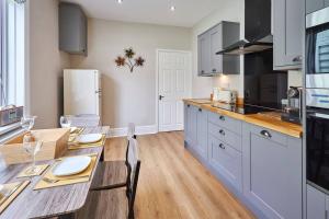 a kitchen with a wooden table and a dining room at Pass the Keys Modern home in a seaside town in Seaham