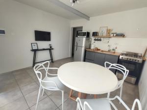 uma cozinha com uma mesa branca e cadeiras num quarto em Los Deptos de Alvear em Santa Rosa