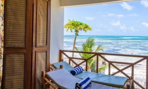 a balcony with chairs and a view of the beach at Pili Pili Boho in Jambiani