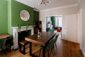 comedor con paredes verdes, mesa y sillas en The Green House 3 Bed House - Families, Contractors, Free Parking, close to racecourse and city centre en Doncaster