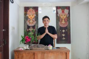 a man standing in a room doing a meditation gesture at Cozy Bungalows in Gili Trawangan