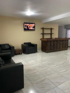 a waiting room with couches and a flat screen tv at Hotel La Toscana in Villa Carlos Paz