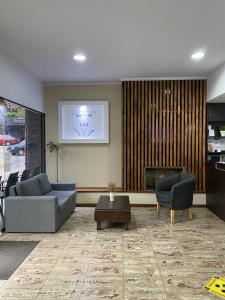 a living room with two couches and a fireplace at Hotel La Toscana in Villa Carlos Paz