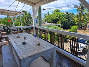 a wooden table on the balcony of a house at Beach front apartment in Grand Gaube