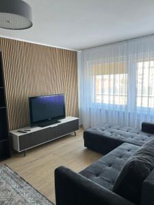 un soggiorno con TV a schermo piatto e divano di BrightNest a Ventspils