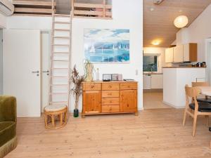 a living room with a wooden cabinet and a ladder at 6 person holiday home in Glesborg in Glesborg