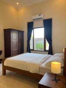 Tempat tidur dalam kamar di Villa Kamboja at The Sunset Beach Resort