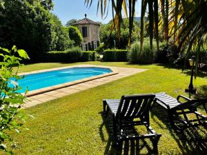 une cour avec deux chaises et une piscine dans l'établissement Les Gîtes et la Chambre de Labahou SPA, à Anduze