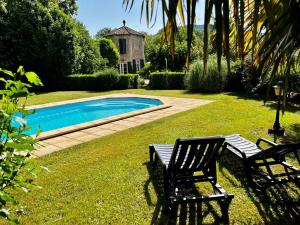 a yard with two chairs and a swimming pool at Les Gîtes et la Chambre de Labahou SPA in Anduze