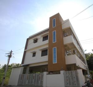 a tall white and brown building at Homestay Thanjavur - 2 Bed Room Apartment in Thanjāvūr