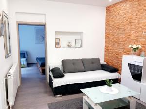 sala de estar con sofá y pared de ladrillo en Apartment Centar en Slavonski Brod