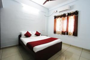 a bedroom with a bed with red pillows at Homestay Thanjavur - 2 Bed Room Apartment in Thanjāvūr