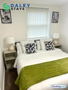 a bedroom with a large bed with green sheets and pillows at Failsworth Luxury Apartment with Free Parking by Daley Stays in Manchester