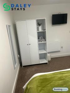 a bedroom with a white cabinet and a tv at Failsworth Luxury Apartment with Free Parking by Daley Stays in Manchester