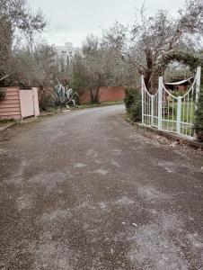 a driveway with a white gate in a yard at Dimora del Conte in Pisa