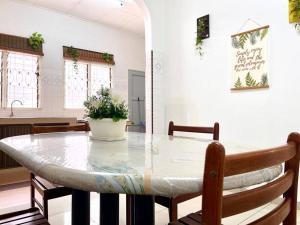 - une table à manger avec une plante en pot dans l'établissement Seaside Bliss: Luxurious 5-Bedroom Retreat, à Malacca