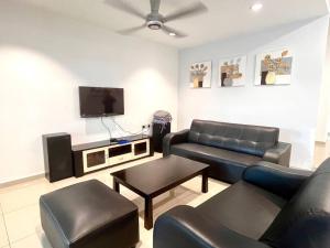 ein Wohnzimmer mit einem Sofa und einem Flachbild-TV in der Unterkunft Seaside Bliss: Luxurious 5-Bedroom Retreat in Malakka