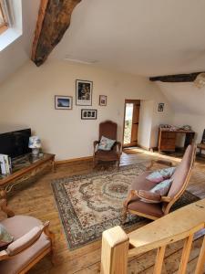 - un salon avec des canapés et un tapis dans l'établissement Vue Du Vallon, à Bersac-sur-Rivalier