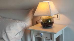 eine Lampe auf einem Tisch neben einem Bett in der Unterkunft Tenuta il Bosco in Bitonto