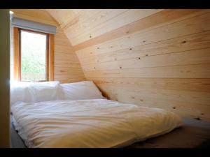 a bed in a room with a wooden wall at South Kerry Glamping in Cahersiveen