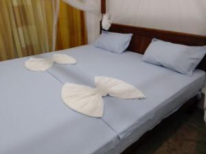- un lit avec des draps blancs et 2 oreillers dans l'établissement Saimon Villa, à Mirissa