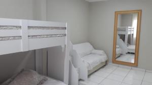 sypialnia z łóżkiem piętrowym i lustrem w obiekcie Espaço de praia acolhedor para família e pets w mieście Matinhos
