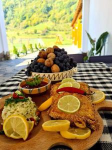 a plate of food with fish and a bowl of fruit at Casa Vădeanu in Sighetu Marmaţiei