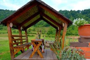 a wooden gazebo with a bench and a table at Casa Vădeanu in Sighetu Marmaţiei