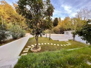 Cottage chaleureux avec jacuzzi en pleine nature في جراس: شجرة في وسط الفناء