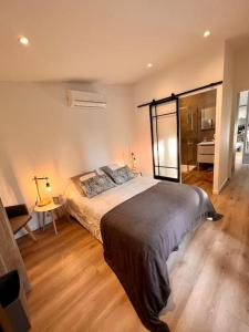 een slaapkamer met een groot bed en een badkamer bij Cottage chaleureux avec jacuzzi en pleine nature in Grasse