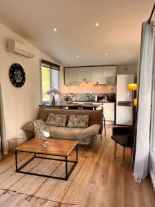 een woonkamer met een bank en een tafel bij Cottage chaleureux avec jacuzzi en pleine nature in Grasse
