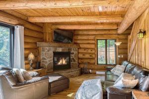a living room with a fireplace in a log cabin at Luxurious log cabin with private spa in Lac-Superieur