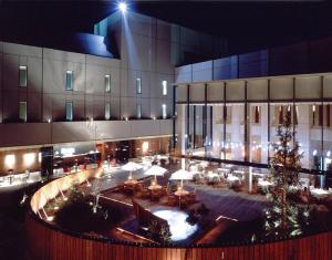 川崎市にあるホテルモリノ新百合丘のテーブルと椅子のある中庭付きの大きな建物