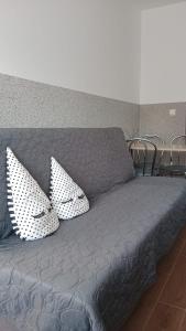 kanapę z dwoma poduszkami na górze w obiekcie Gościnne mieszkania M2 w mieście Białystok
