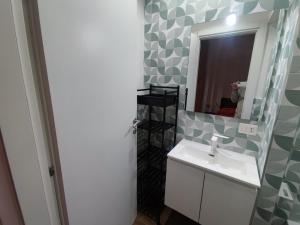 un baño con lavabo y espejo en New Malù apartment, en Bari