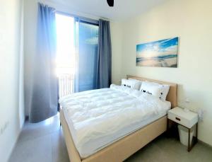 een slaapkamer met een groot bed en een raam bij Spacious New 1BD Levinski Florentin in Tel Aviv