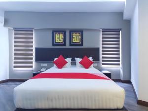 una camera da letto con un grande letto bianco con cuscini rossi di RPC Blissful Homes & Hotel a Kuala Lumpur