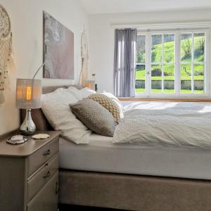 a bedroom with a bed with a window and a dresser at peaceful tiny house near forest in Rorschacherberg