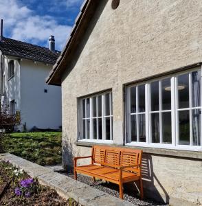 a wooden bench sitting in front of a house at peaceful tiny house near forest in Rorschacherberg