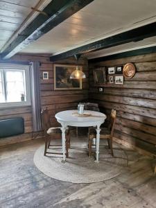 a dining room with a white table and chairs at Stabburet på Balsnes Gård in Hitra
