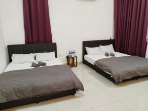 two beds sitting next to each other in a bedroom at KSP Guest House in Melaka