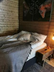 a bedroom with a bed and a table with a lamp at Stabburet på Balsnes Gård in Hitra