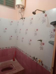 a bathroom with a pink tub with flowers on the wall at SriArunachala Shiva home stay in Tiruvannāmalai