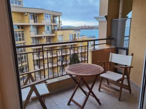 een balkon met een tafel en stoelen en uitzicht op een gebouw bij DL Apartments in Aheloy