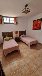 1 dormitorio con 2 camas y suelo de baldosa en Yurena´s Corner en Arrecife