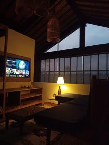 a living room with a tv and a table and a lamp at Baku living villa in Ngaglik