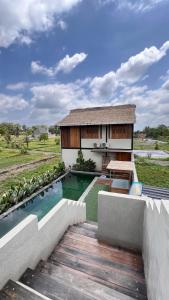 a villa with a swimming pool and a house at Baku living villa in Ngaglik