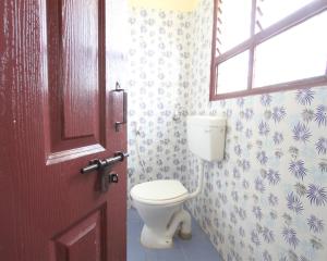 a bathroom with a toilet and a window at Homestay Thanjavur - 2 Bed Room Apartment in Thanjāvūr
