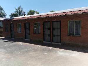 einem roten Backsteingebäude mit vergitterten Fenstern in der Unterkunft P & T Guesthouses in Pietermaritzburg